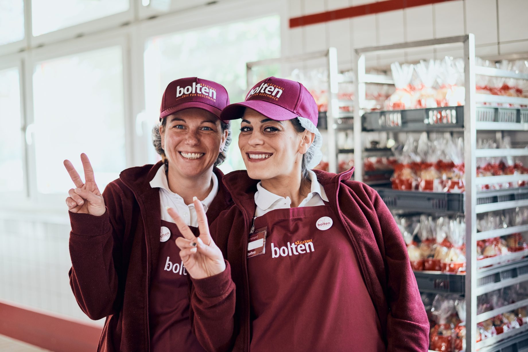 2 Mitarbeiterinnen lächeln in der Produktion der Bäckerei Bolten.