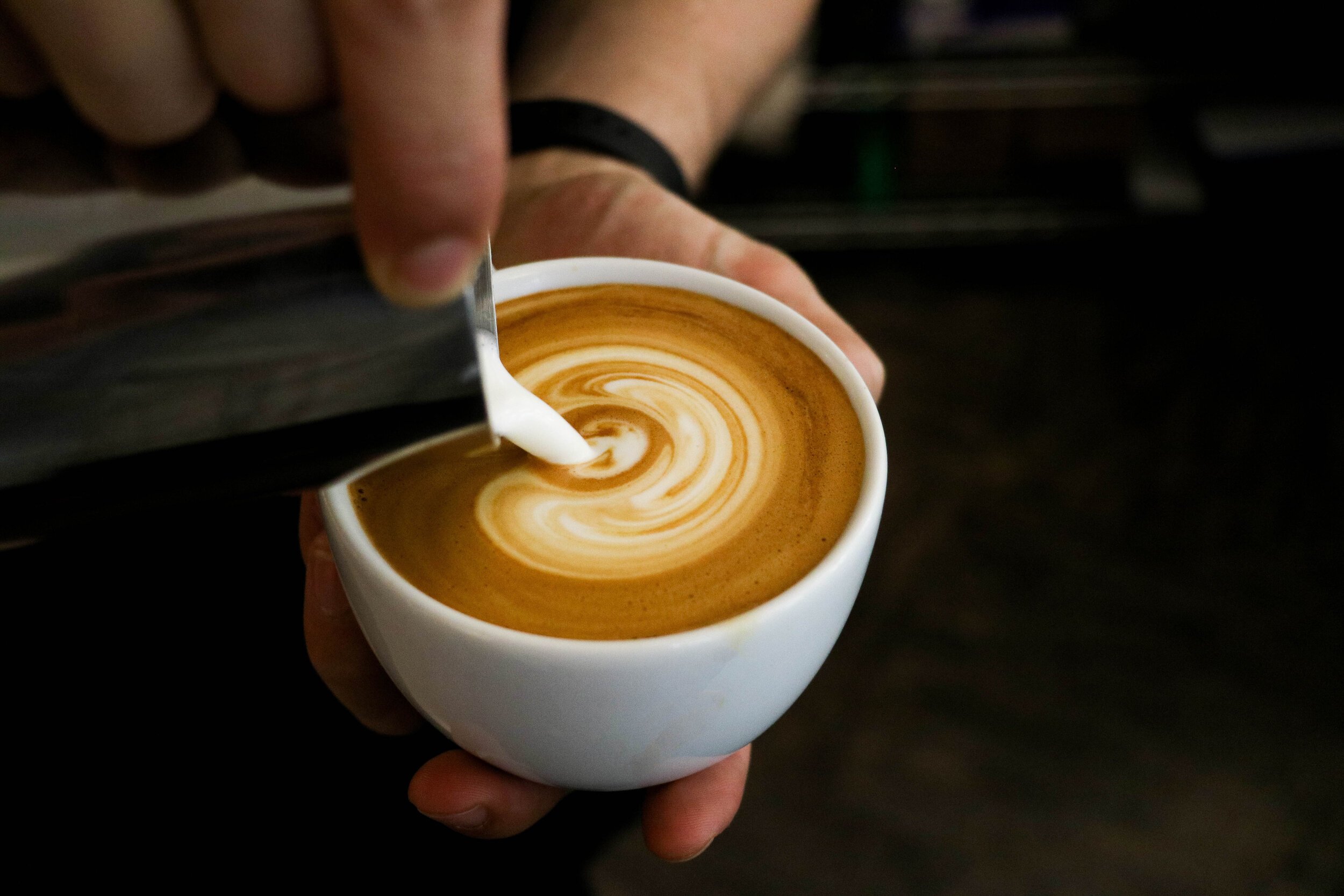 Milch wird in Kaffee gegossen.